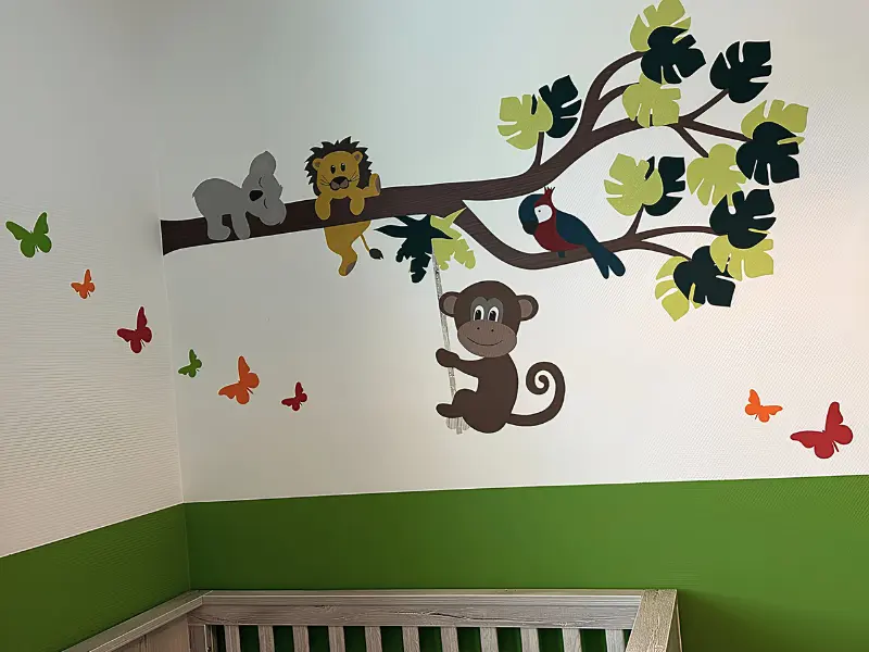 Vrolijke groene babykamer met een jungle behangsticker